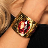 Pulsera de metal dorado con joya roja
